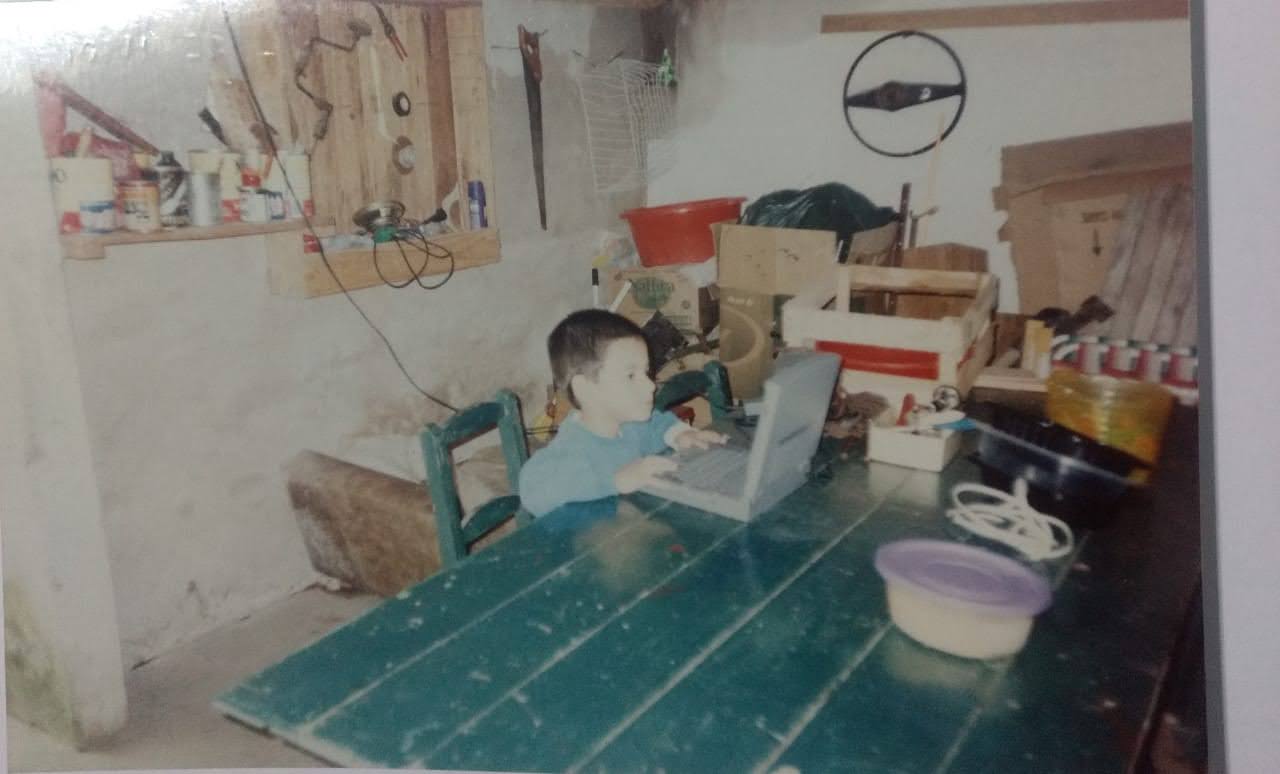 De niño, con una computadora en el taller de casa